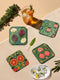 Set of four square drinking coasters featuring rich, dark green botanical illustration with highly detailed Pomegranate fruits and sliced cross-sections. The ornate pattern utilizes deep crimson, opulent gold, and ivory tones, strongly reflecting the stylized Art Nouveau period aesthetic and William Morris textile designs. Crafted from durable, resilient masonite hardboard, this luxury item features a protective high-gloss finish and a non-slip cork base.